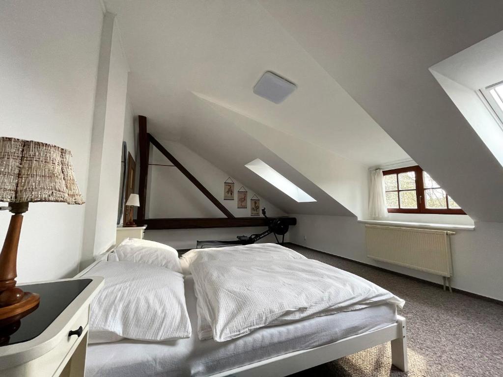 a white bedroom with a bed and a window at Apartmán U Hradeb Tachov in Tachov