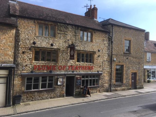 a brick building on the side of a street at The Plume of Feathers in Sherborne