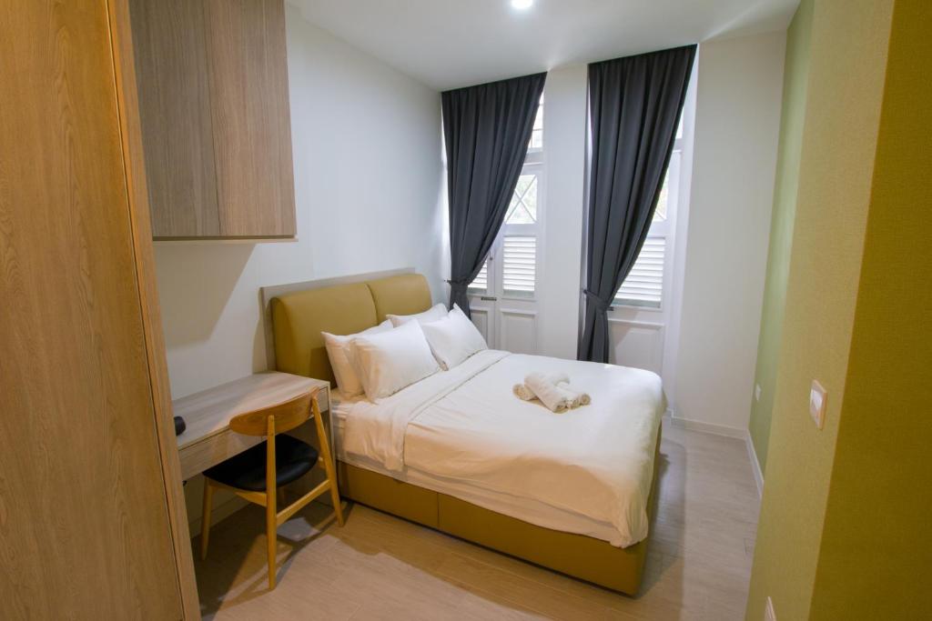a small bedroom with a bed and a desk at Cantonment Serviced Apartment in Singapore