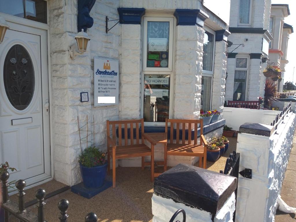a building with two chairs and a table outside at Sandcastles Guest House in Great Yarmouth