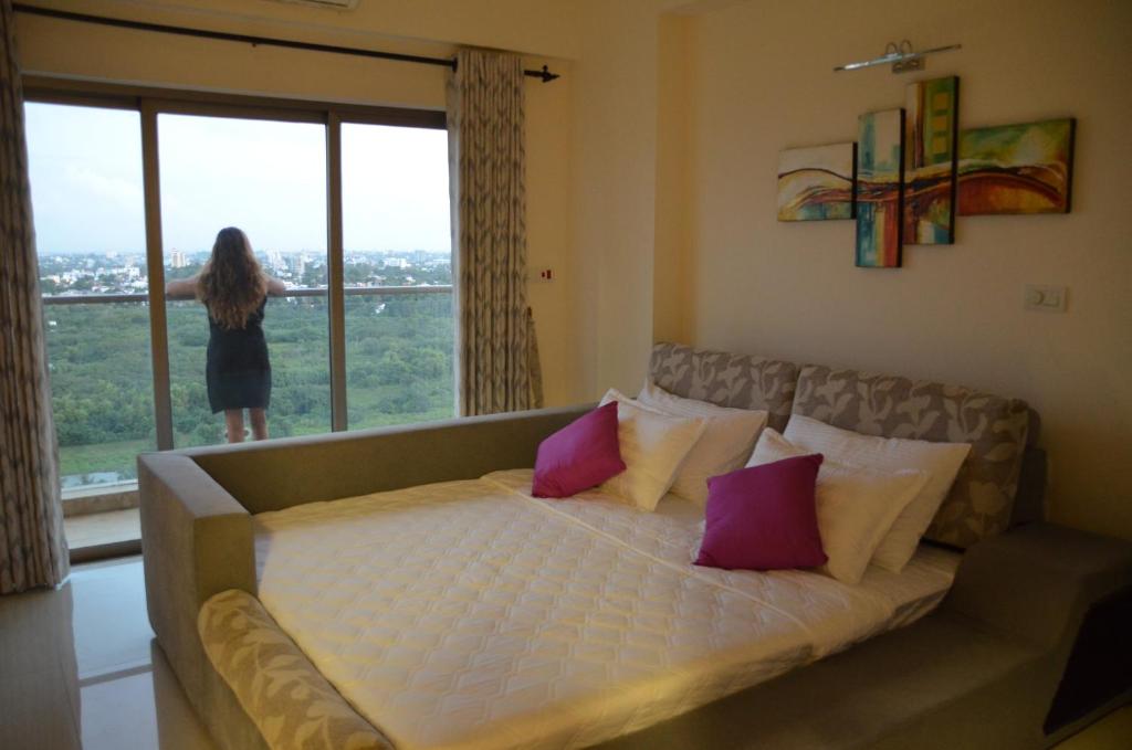 斯里賈亞瓦德納普拉科特的住宿－Atrium - ICONIC APARTMENT，站在有床的房间的女人