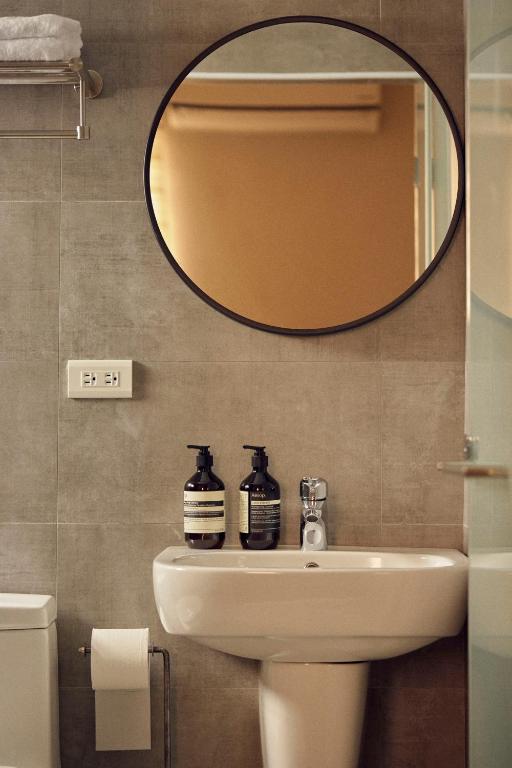 un bagno con lavandino e specchio di Sunlight Homestay a Magong