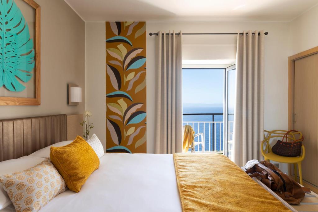 - une chambre avec un lit et une vue sur l'océan dans l'établissement Santateresa, à Bonifacio