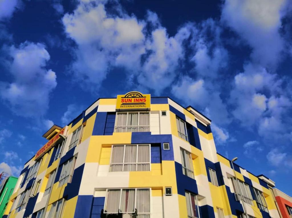 a yellow and blue building with a sign on it at Sun Inns Hotel Meru Raya in Chemor
