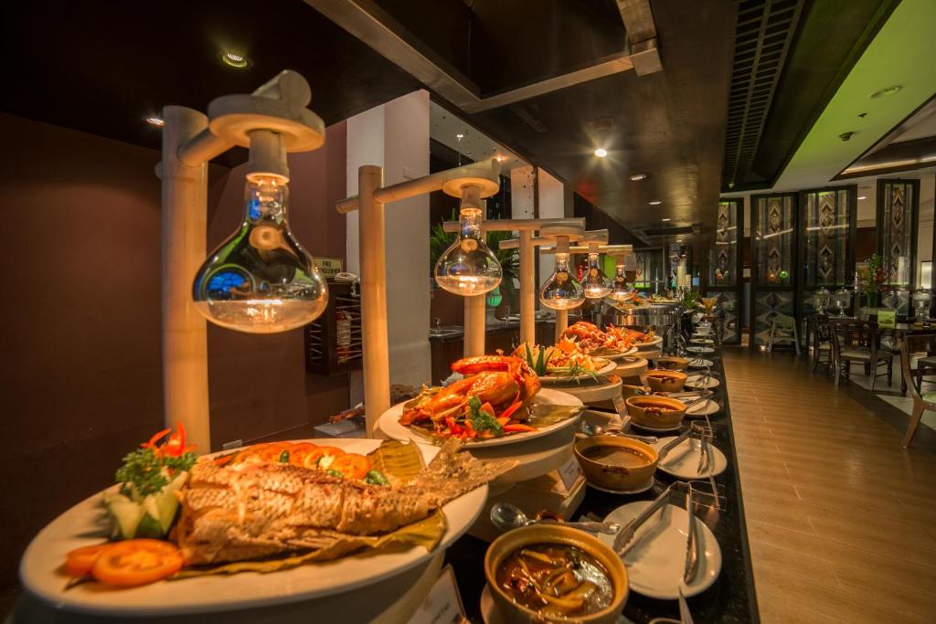 a buffet line with plates of food on a table at Waterfront Airport Hotel and Casino in Mactan