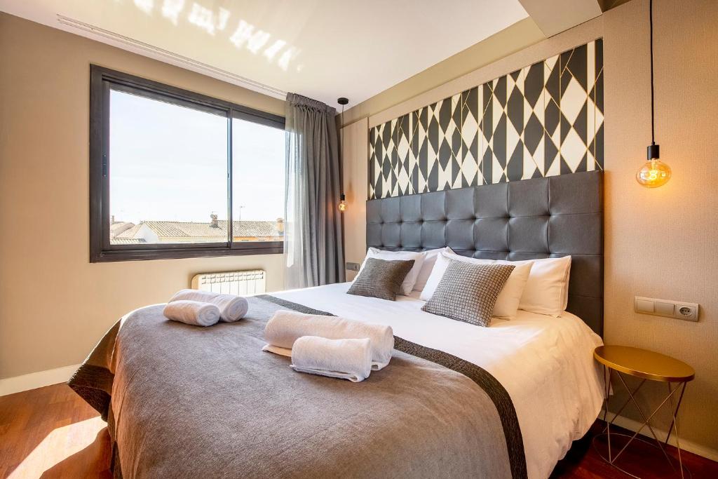 um quarto com uma cama grande com duas toalhas em UP ROOMS BANYOLES em Banyoles