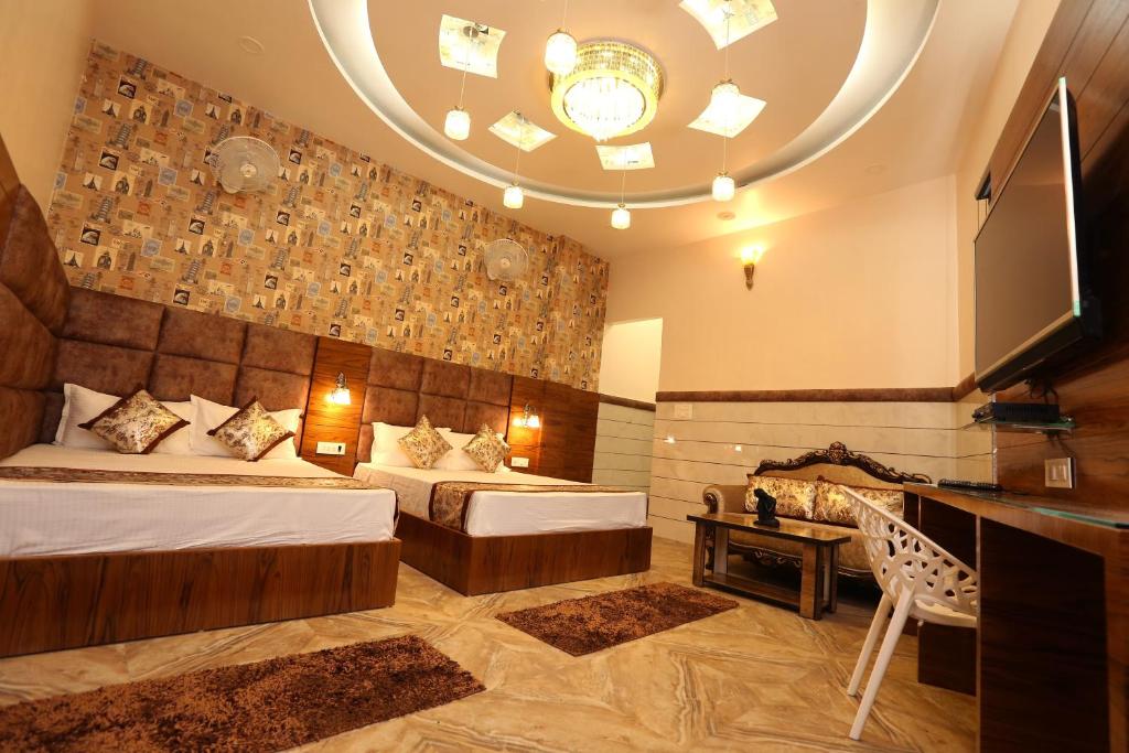 a hotel room with two beds and a television at The Park View Hotel in Amritsar