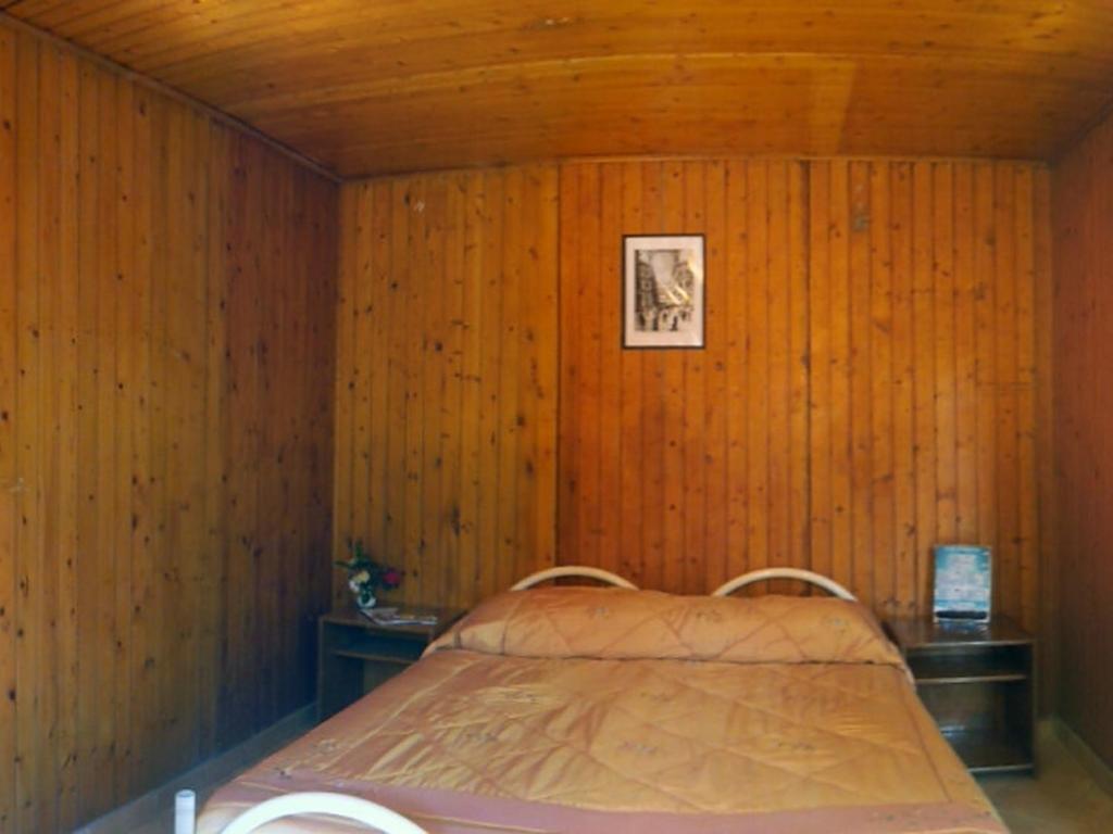 a bedroom with a bed in a wooden wall at Fiori D'Arancio in Piano di Sorrento