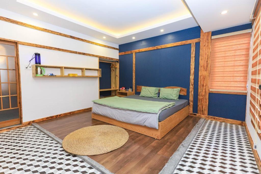 1 dormitorio con cama y pared azul en Japan Homestay Quy Nhon en Quy Nhon