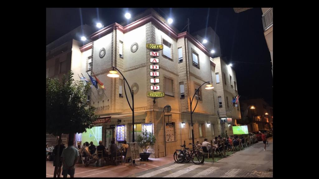un bâtiment avec un panneau de néon sur son côté dans l'établissement Hotel Madrid, à Santiago de la Ribera