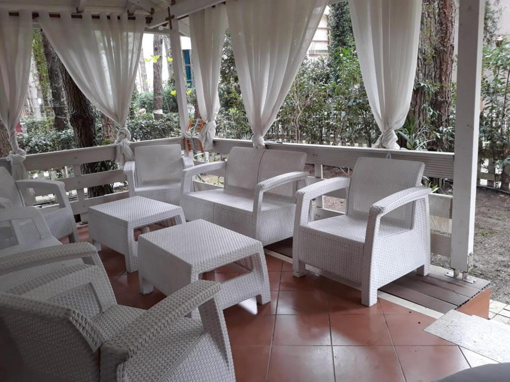 a group of chairs and tables on a porch at A beautiful Beach house Marea Resort in Golem