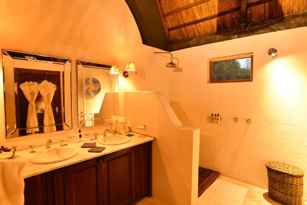 a bathroom with two sinks and a large mirror at Royal Zambezi Lodge in Mafuta
