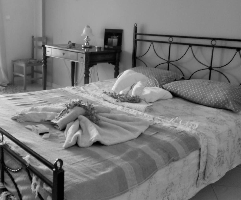 ein schwarz-weißes Foto eines Bettes mit Handtüchern darauf in der Unterkunft Afrodite Lefkimmi Apartment 1 in Lefkímmi