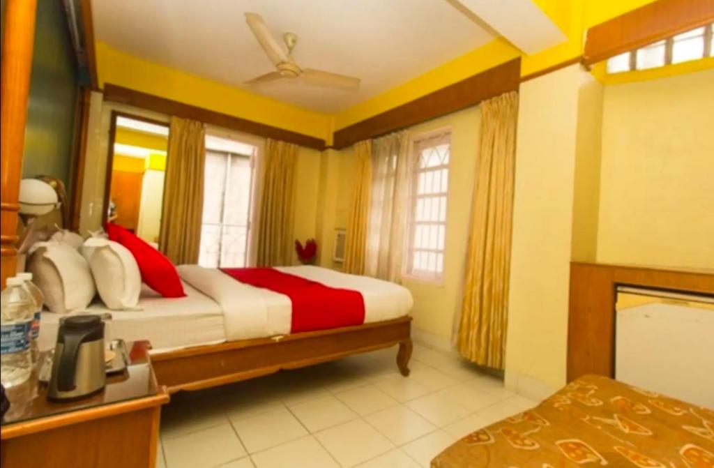 um quarto com uma cama com almofadas vermelhas e brancas em Budget Stay near Cart road em Siliguri