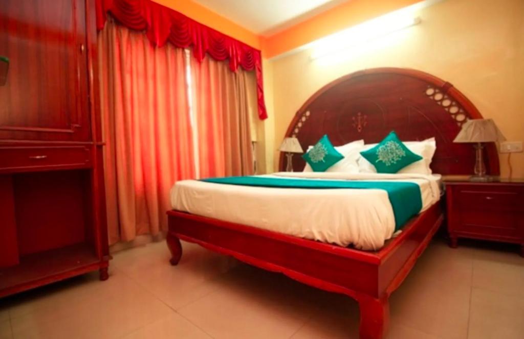1 dormitorio con 1 cama grande y cabecero de madera en Budget Stay near Cart road en Siliguri