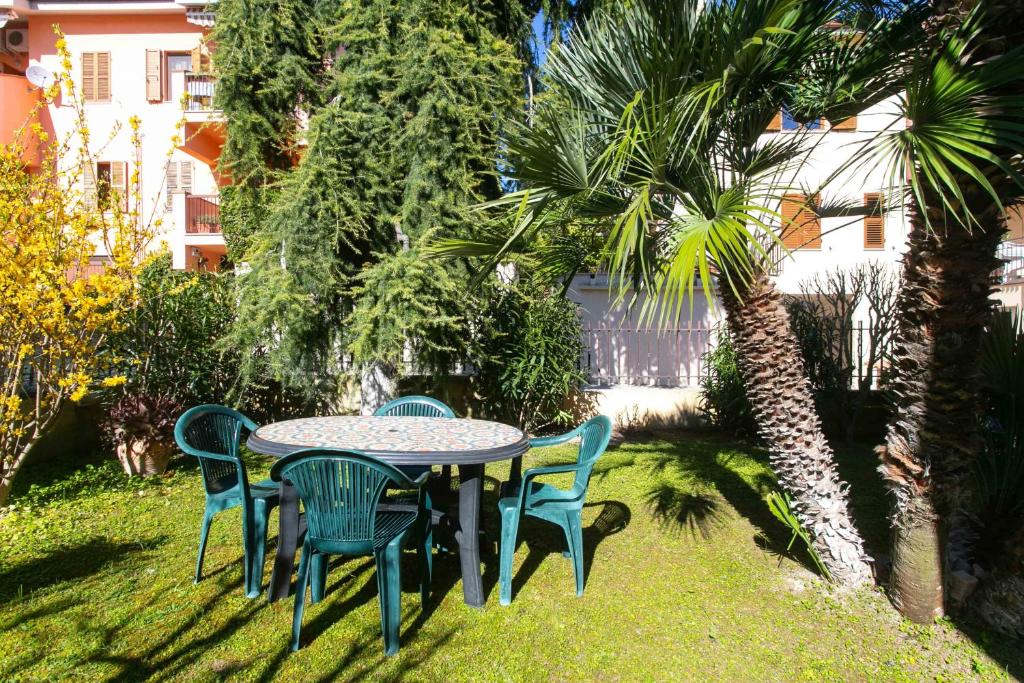 un tavolo e sedie in un cortile con una palma di N043 - Numana, bilocale con giardino a Sirolo