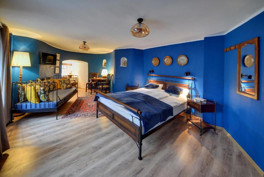 sypialnia z niebieskimi ścianami i łóżkiem w pokoju w obiekcie Baszta Grodzka w Jeleniej Górze