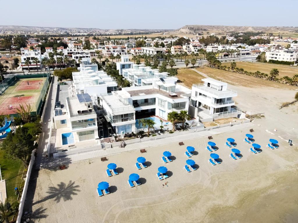 - une vue aérienne sur une plage dotée de chaises bleues et de bâtiments dans l'établissement Touch Blue Residences, à Larnaka