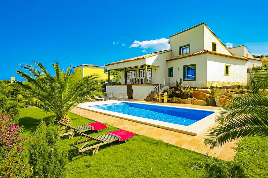 a villa with a swimming pool in front of a house at 0338 Villa Elefante Tia in Jávea