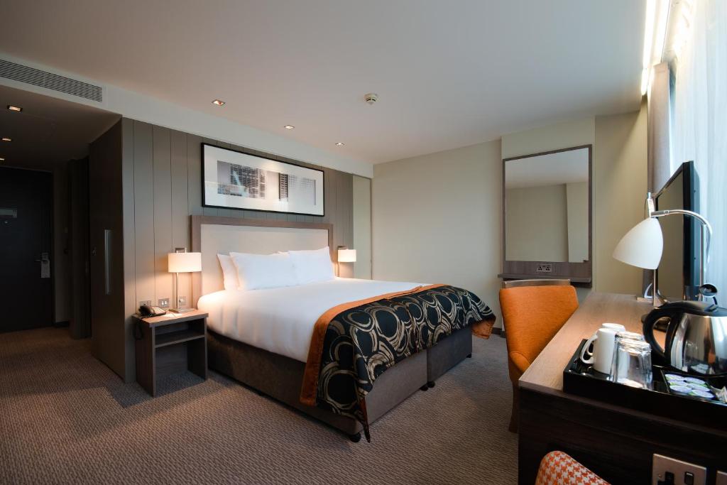 a hotel room with a bed and a television at Clayton Hotel Chiswick in London
