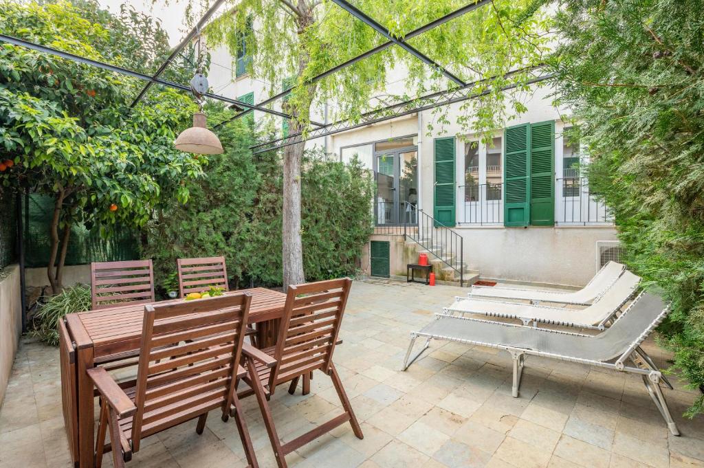 a patio with two chairs and a table and a bench at Casa Sunny in Port de Soller