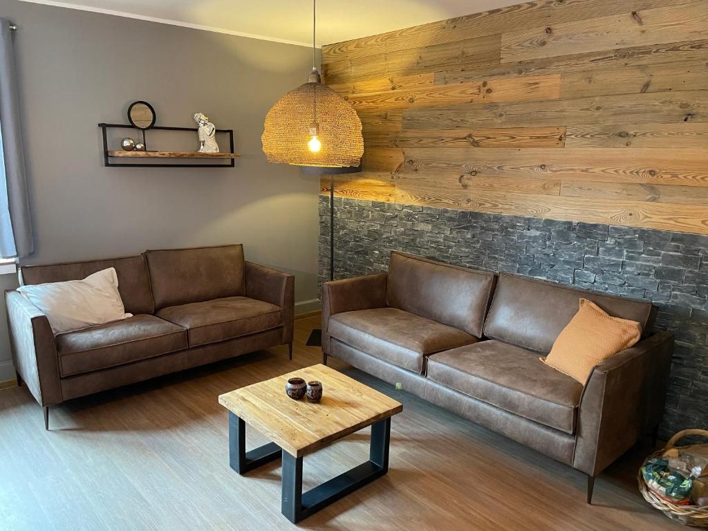 ein Wohnzimmer mit 2 Sofas und einem Tisch in der Unterkunft Haus Wunschlos Auf Aderich in Monschau
