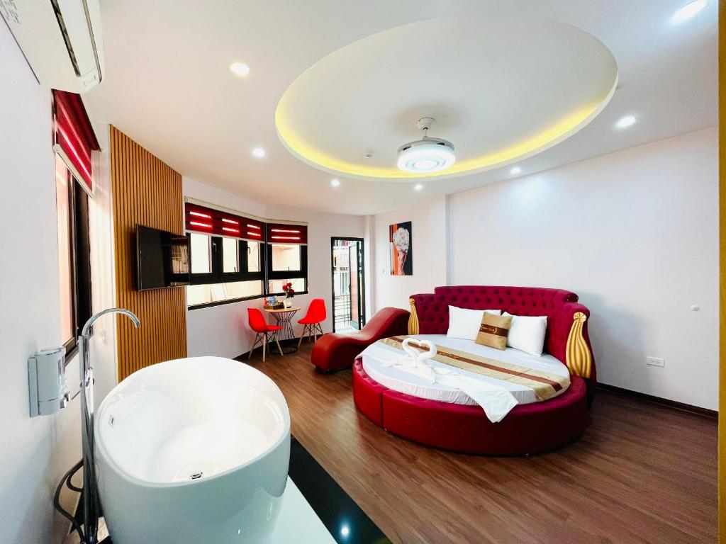 Schlafzimmer mit einem großen roten Bett und einer Badewanne in der Unterkunft A&EM VILLA in Hanoi