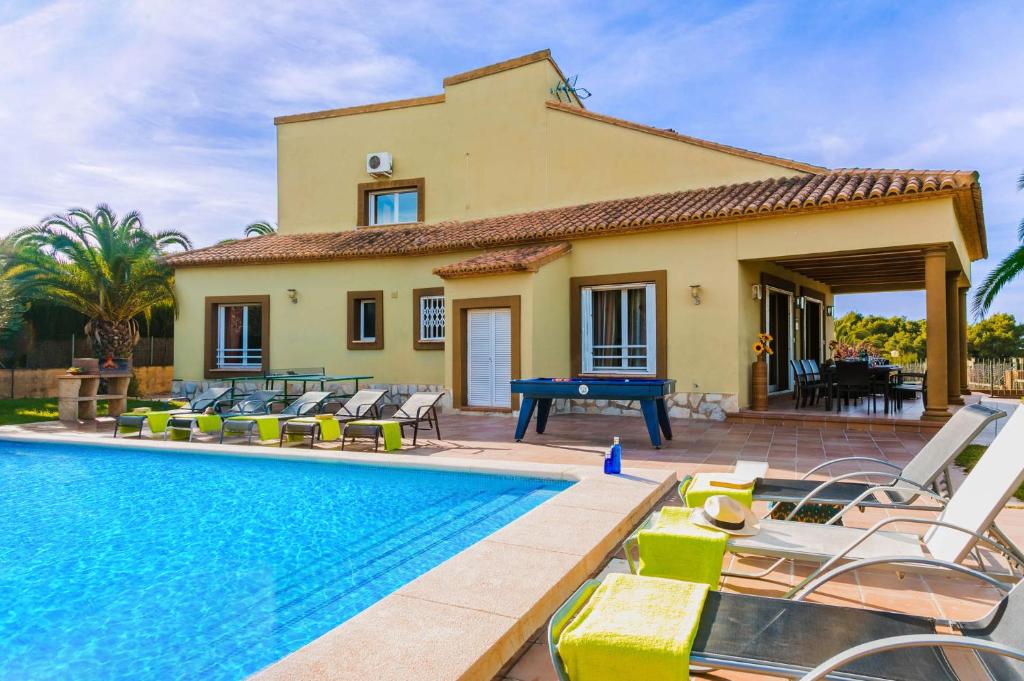 een villa met een zwembad en een huis bij 0350 Villa Elefante Tia in Jávea