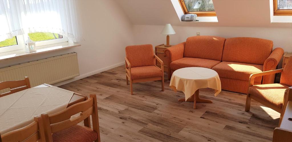 ein Wohnzimmer mit einem Sofa, einem Tisch und Stühlen in der Unterkunft Landhaus Braband Ferienwohnungen - Gustav-Schönleber-Weg 2 in Cuxhaven