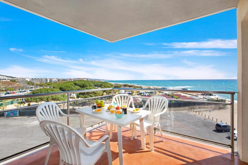 a balcony with a table and chairs and the ocean at Santa Susanna Sunrise Apartment in Santa Susanna