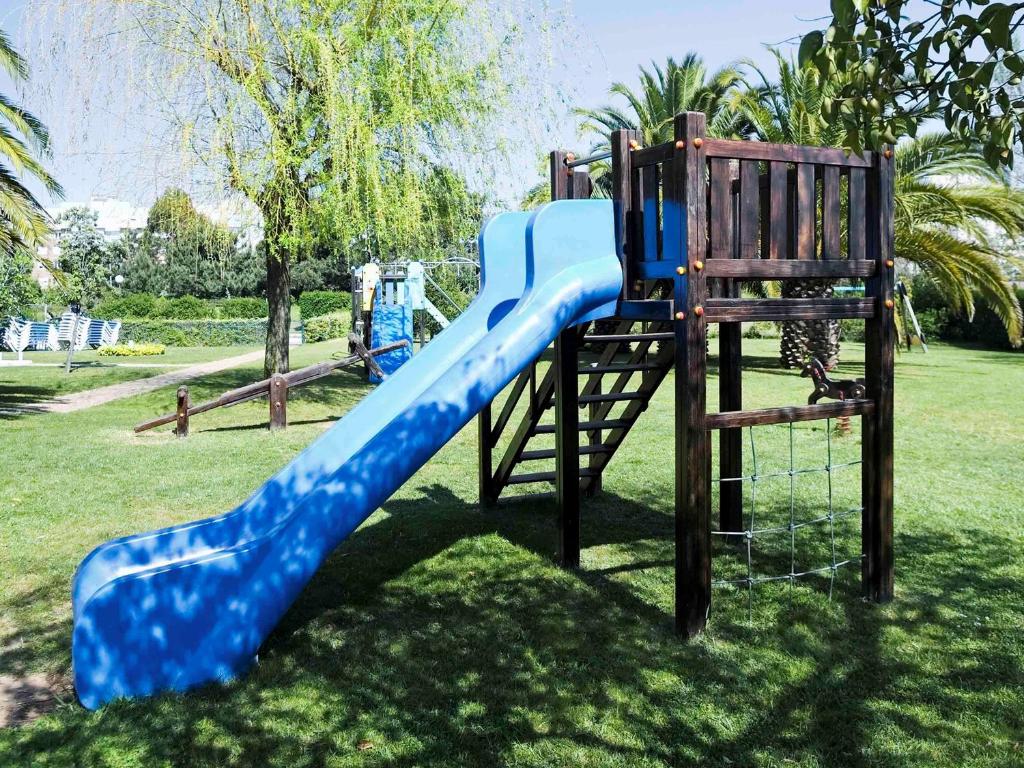 a blue slide on a playground in a park at Novotel Porto Gaia in Vila Nova de Gaia