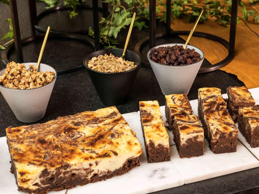 a group of desserts on a table with bowls of food at Novotel Porto Gaia in Vila Nova de Gaia