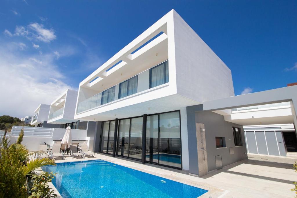 uma grande casa branca com piscina em Diamond villas em Protaras