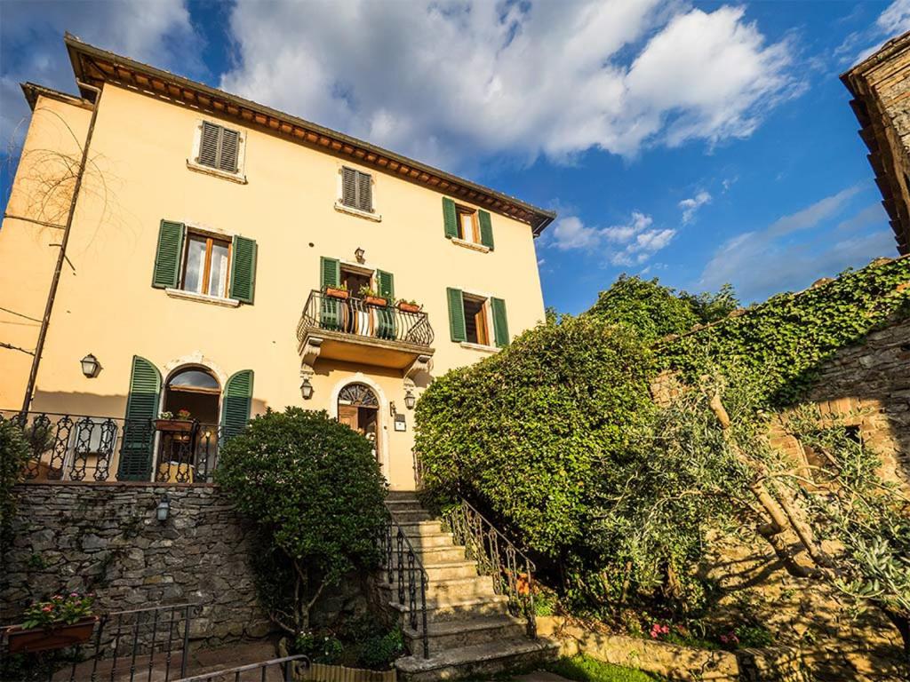 una casa grande con escaleras que conducen a ella en Paradiso in Chianti en Gaiole in Chianti