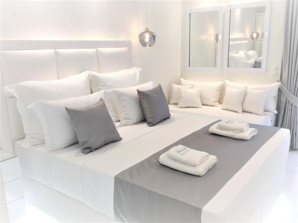 um quarto branco com duas almofadas brancas numa cama em Amaryllis Luxury Rooms em Platamonas
