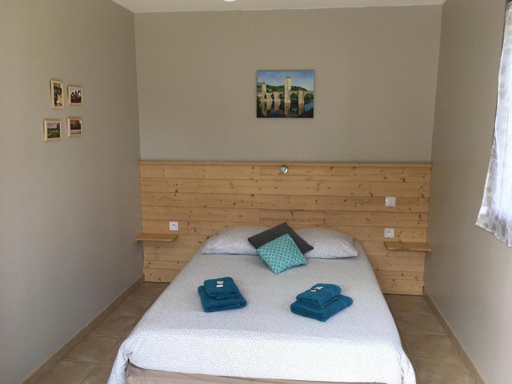 - une chambre avec un lit doté d'oreillers bleus dans l'établissement Le Mas des 3 Anes, à Blars