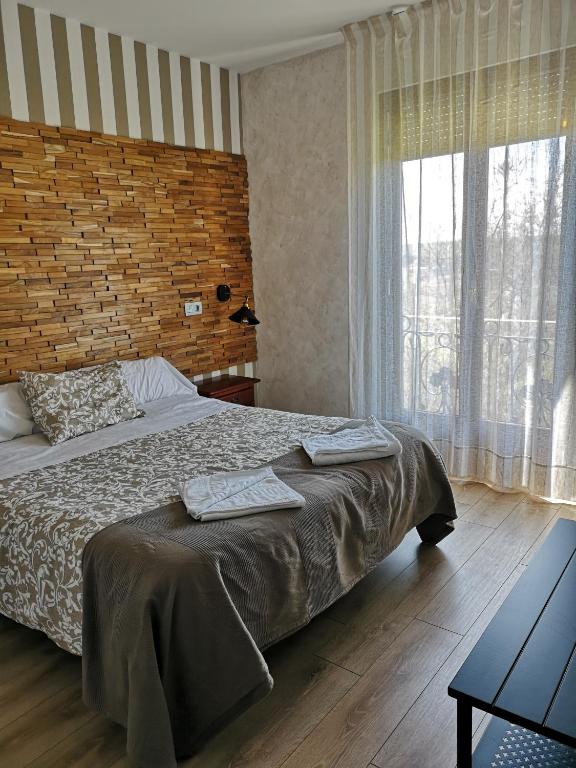 Un dormitorio con una cama y una ventana grande. en Hostal Juan Bravo, en Segovia