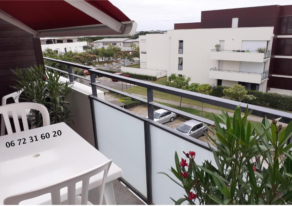 d'un balcon avec une table et une vue sur un bâtiment. dans l'établissement Les terrasses de Mirande, à La Rochelle