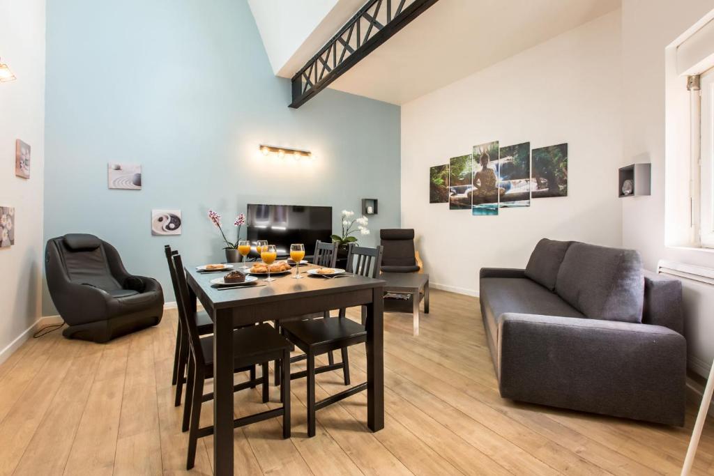 a living room with a table and a couch at Le ZEN... appartement avec fauteuil massant! in Tourcoing