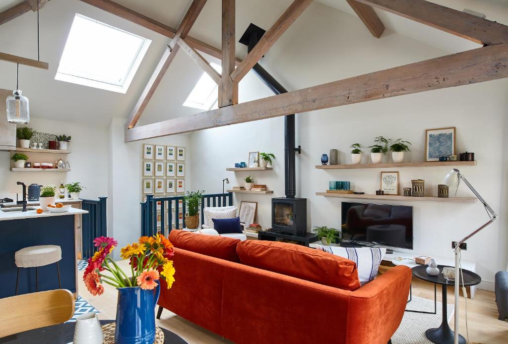 un soggiorno con divano arancione e camino di The Loft House - Beautiful House in Best Location a Bath