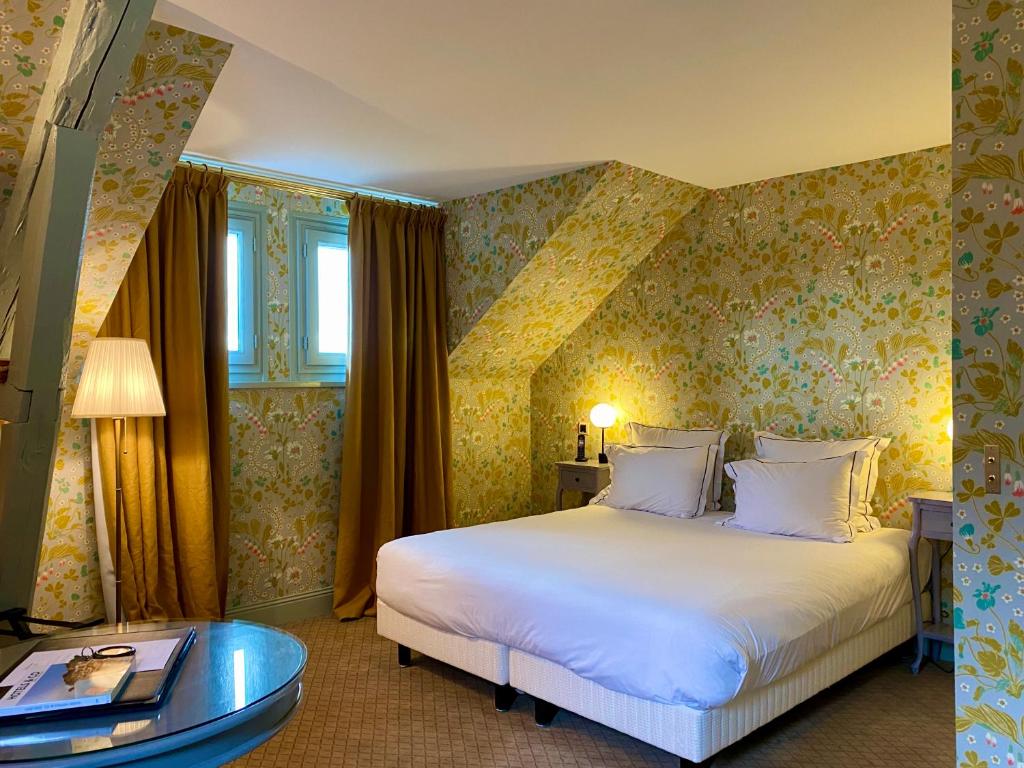 a hotel room with a bed and a table at Domaine Saint Clair - Le Donjon in Étretat