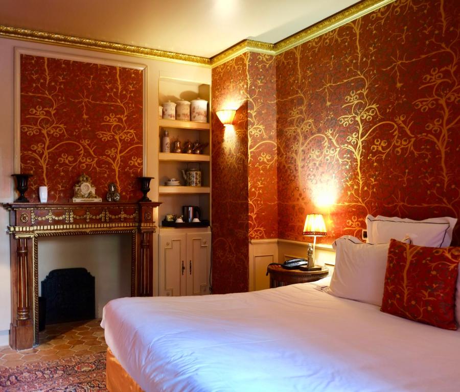 a bedroom with a large bed and a fireplace at Domaine Saint Clair - Le Donjon in Étretat