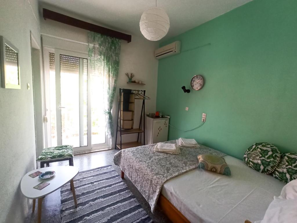 Grünes Zimmer mit 2 Betten und einem Tisch in der Unterkunft Galini in Therma