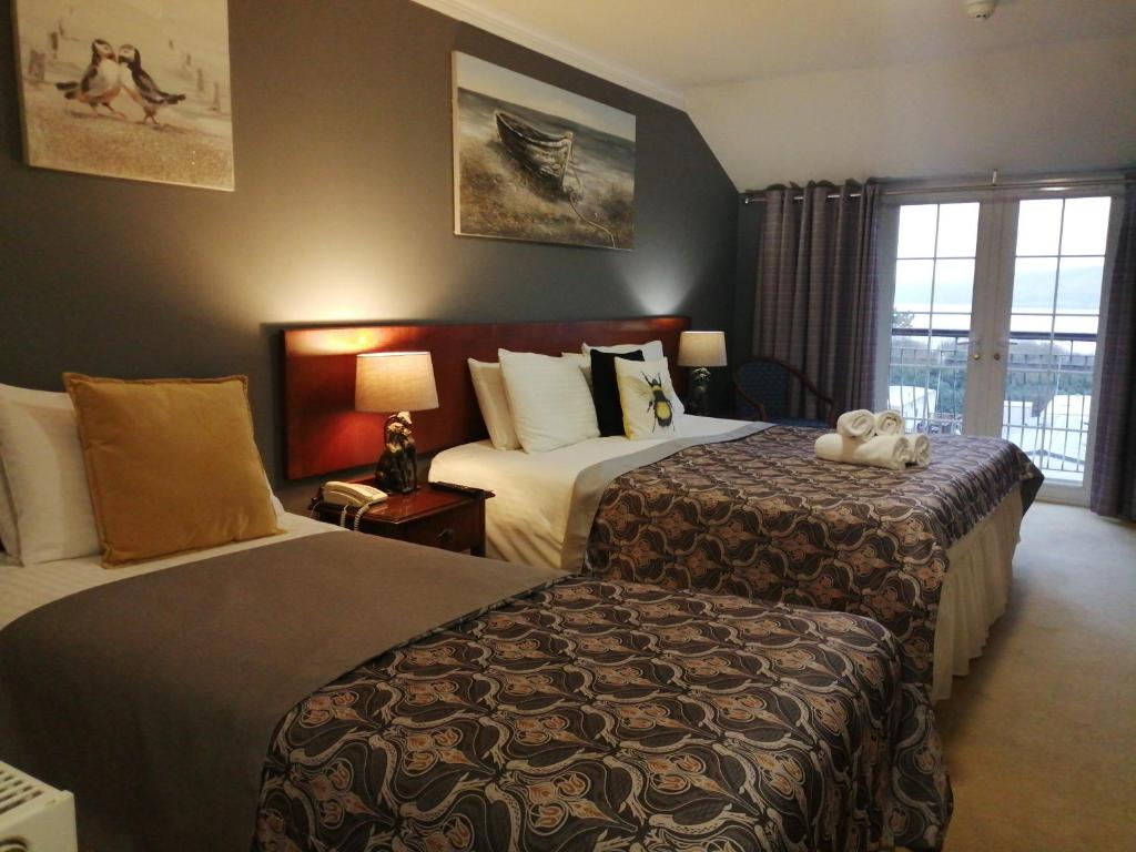 ein Hotelzimmer mit 2 Betten und einem Fenster in der Unterkunft Three Rivers Hotel in Ferryside