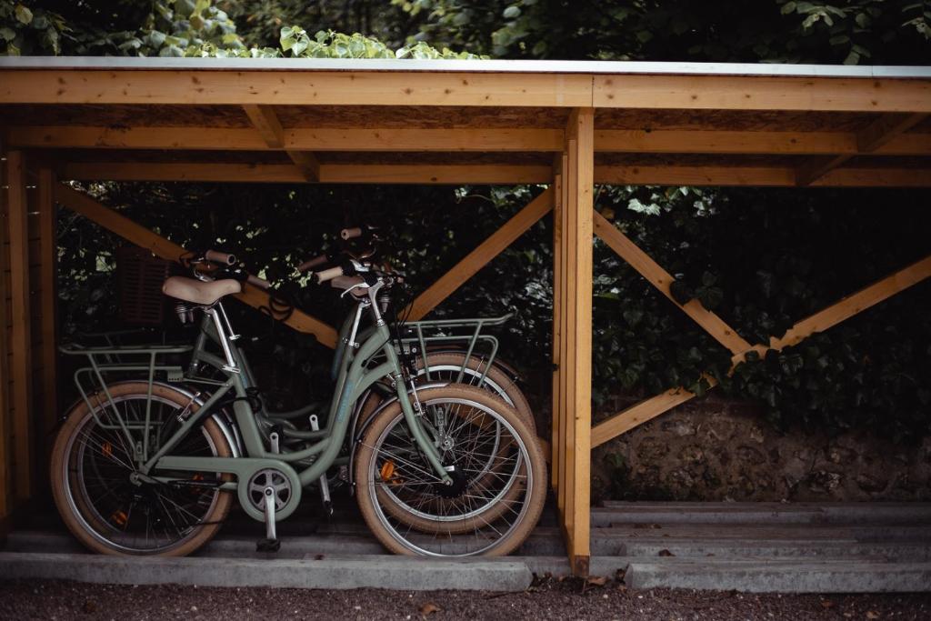 a bike is parked under a wooden structure at Domaine Saint Clair - Le Donjon in Étretat