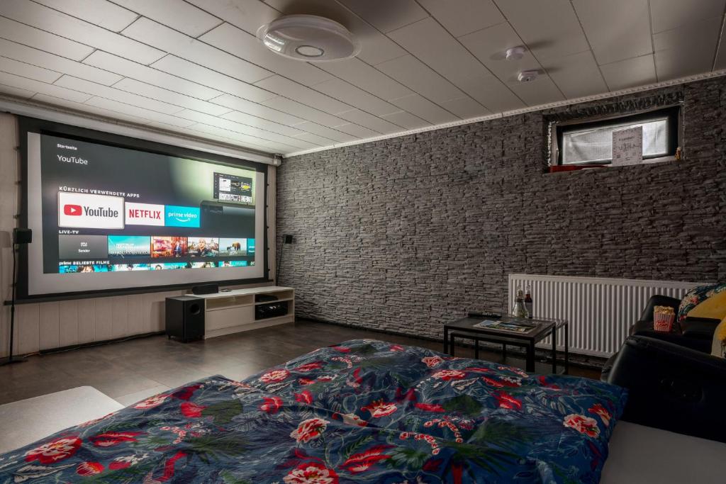 um quarto com uma cama e uma televisão de ecrã grande em Home Cinema Kassel with Netflix and Disney em Kassel