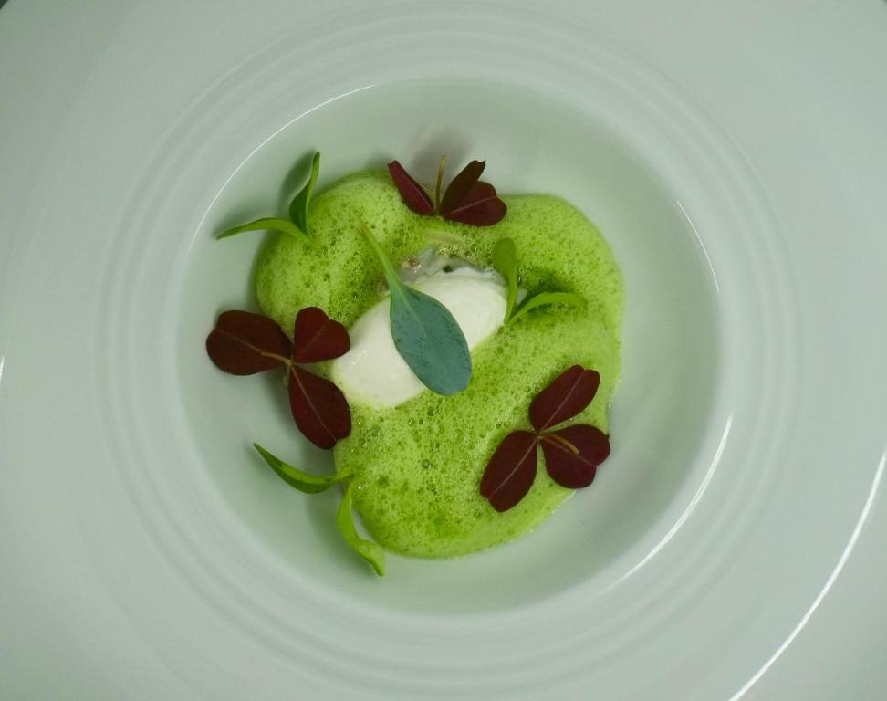 a white plate with some green food on it at Domaine Saint Clair - Le Donjon in Étretat