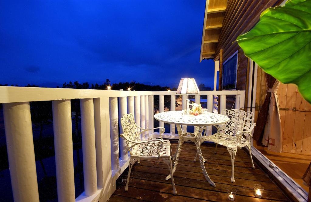 a table and chairs on a porch at night at Dongshan River Resort Farm in Wujie