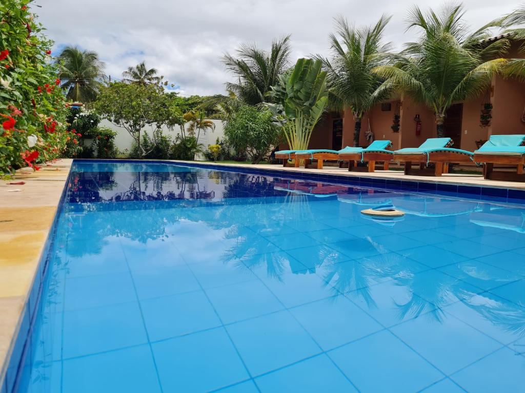a large swimming pool with blue water in a resort at Pousada Bosque Cumbuco in Cumbuco