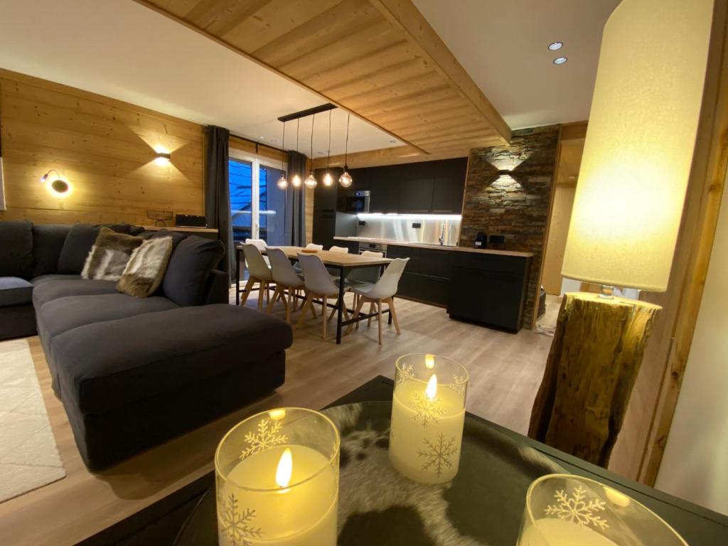 a living room with a couch and a table with candles at L'Etesy, rénové en 2021, pied des pistes et spa in Montgenèvre